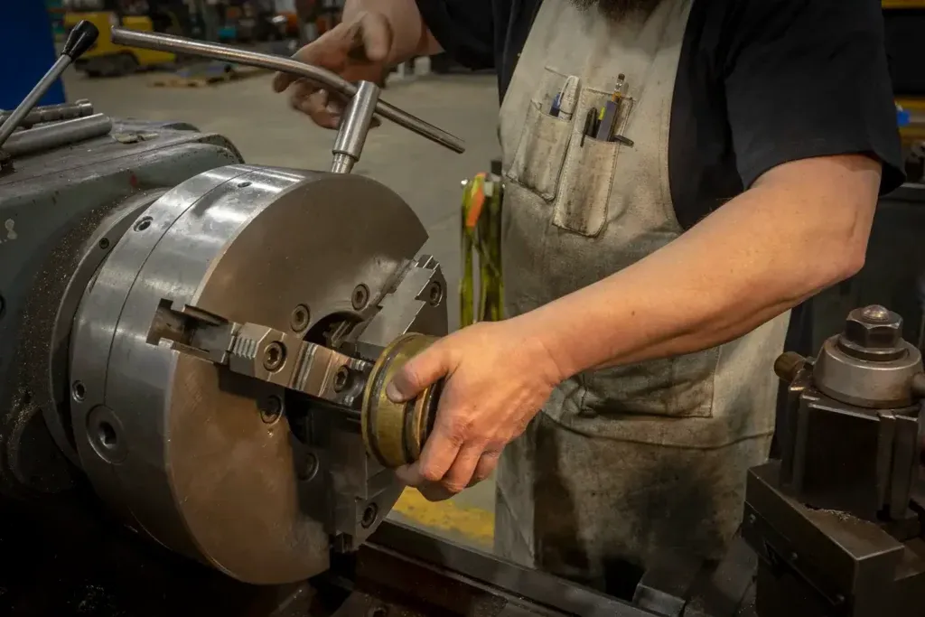 Man repairing cylinder with a machine